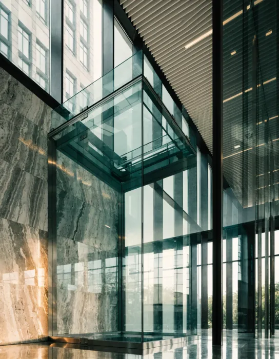 Square panoramic glass elevator in an office lobby